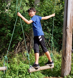 Camper on challenge course obstacle